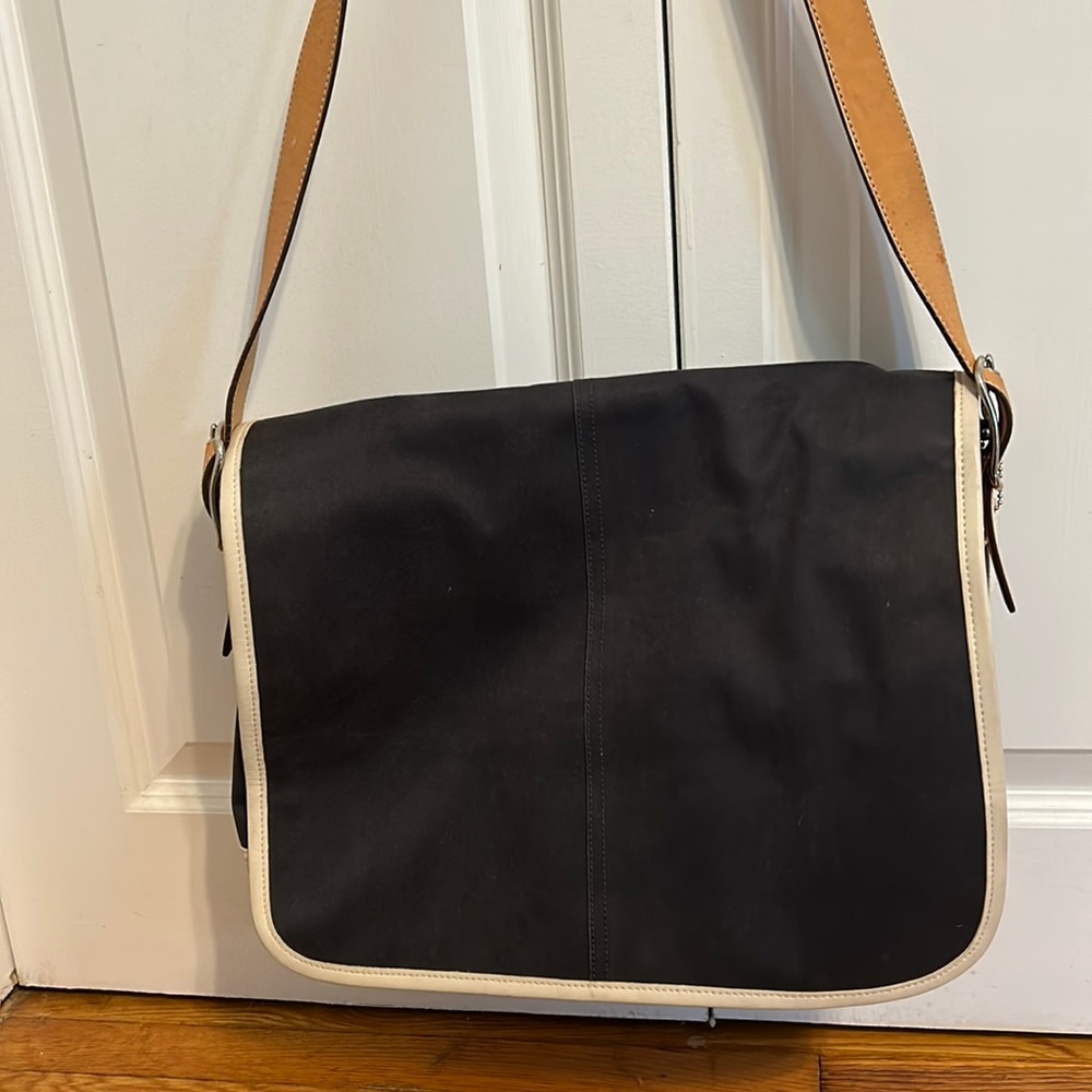 Coach navy blue shoulder bag with interior and exterior pockets.